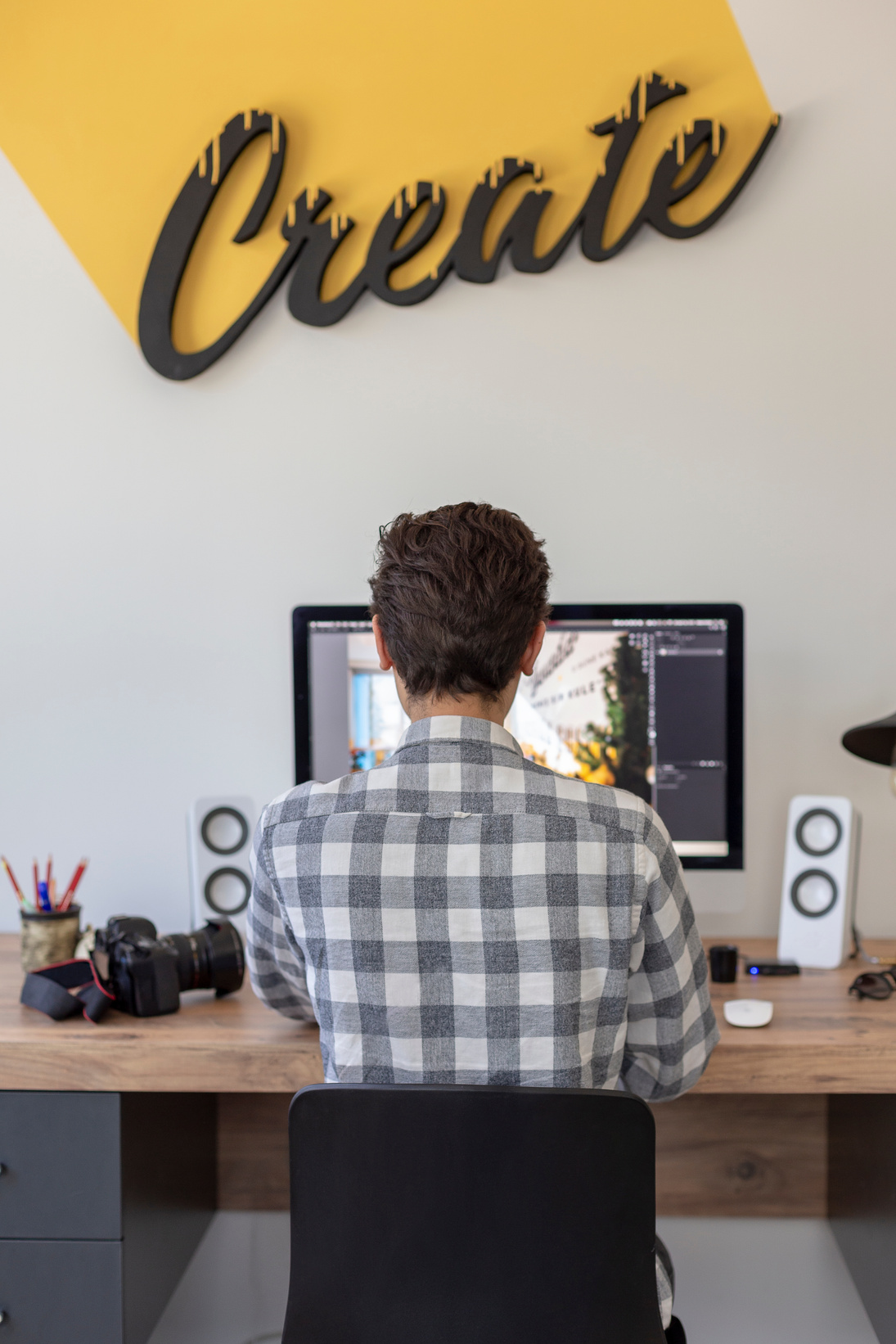 Young male graphic designer or photographer working on computer using digital tablet at office.